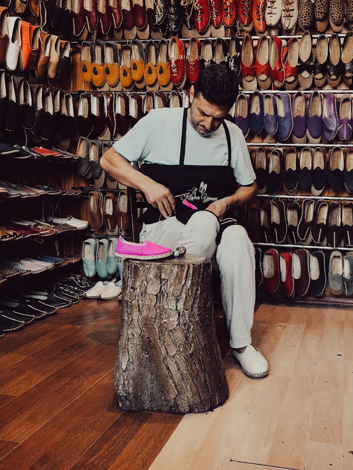Hombre limpiando y cosiendo zapatos de cuero